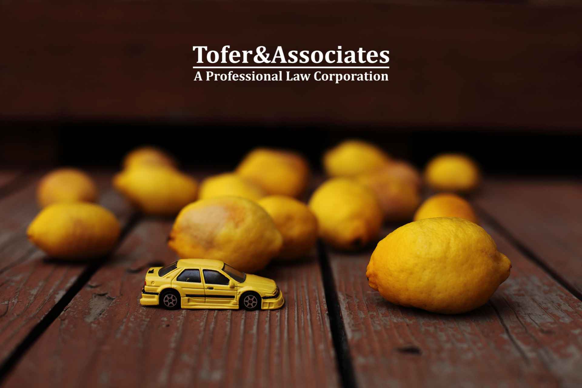 Toy car surrounded by lemons representing Tofer & Associates' focus on lemon law cases.