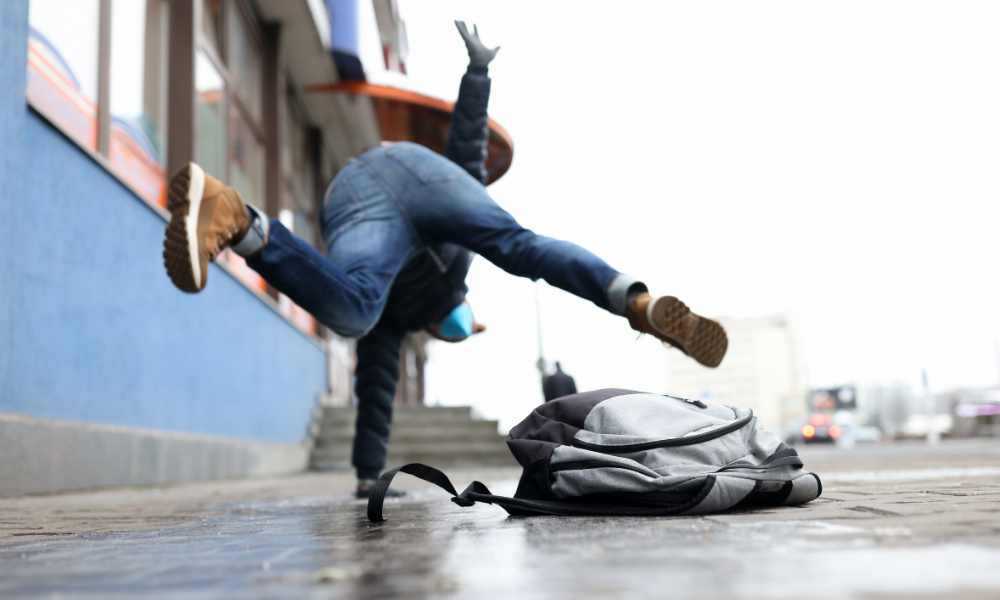Person falling on a sidewalk, illustrating an outdoor slip and fall injury in California.