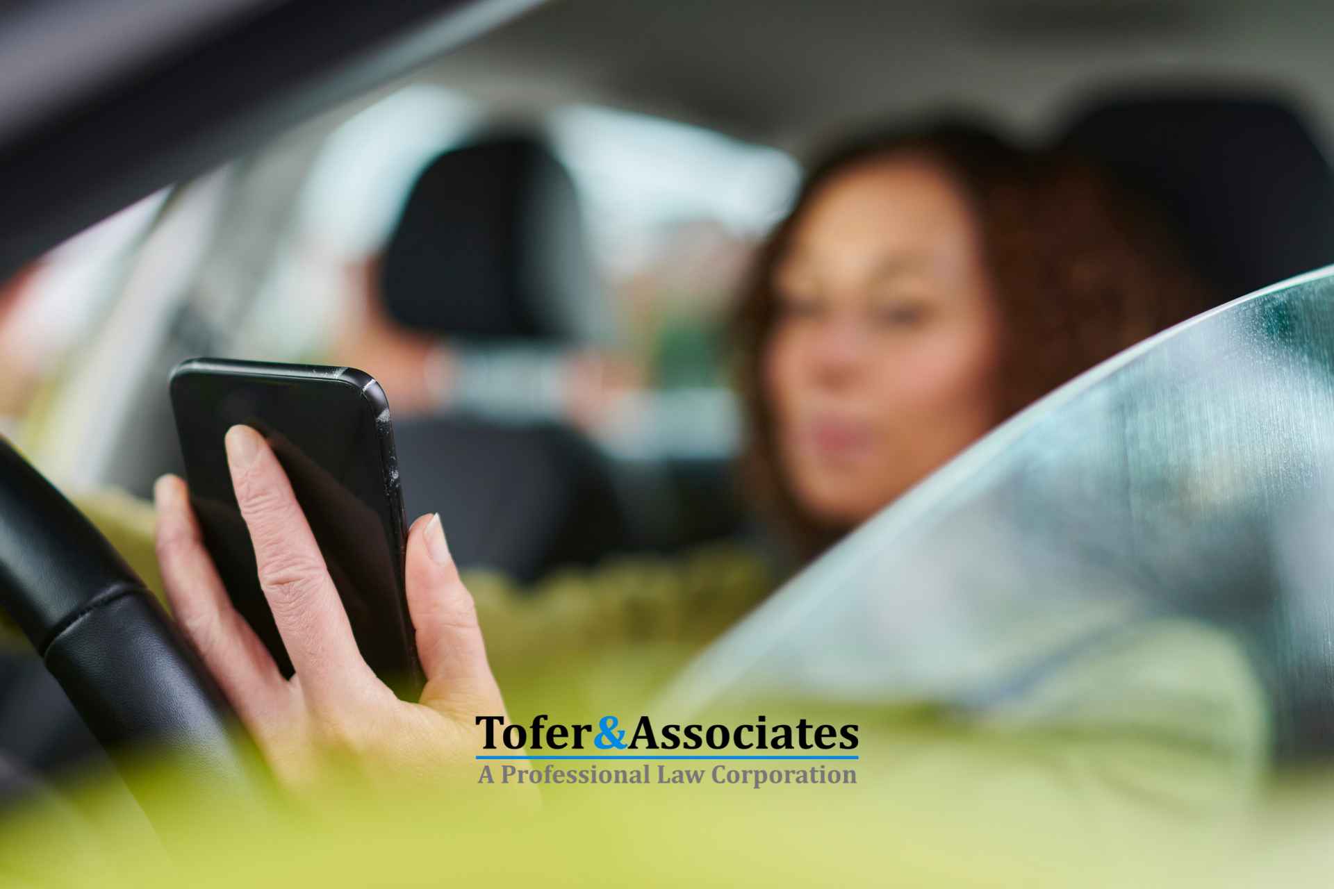 A woman using the phone while driving in a California road.